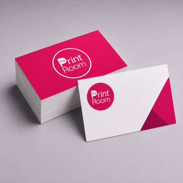 Stack of premium Print Room standard business cards featuring a modern round logo design, with a single branded business card displayed in front on a soft grey studio background.