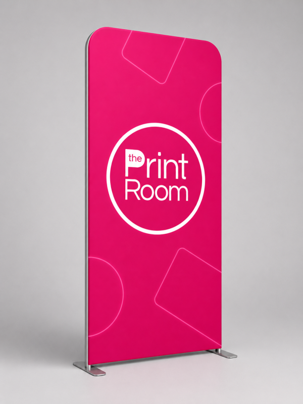 Curved fabric exhibition display featuring The Print Room round magenta logo on a vibrant pink background with subtle geometric accents, mounted on a freestanding silver frame against a neutral grey studio background.