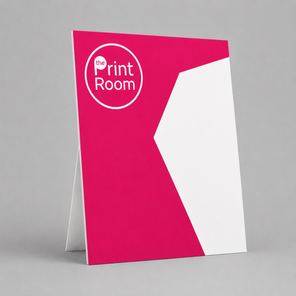 Strut card display featuring The Print Room round magenta logo, a modern pink and white geometric design, and a freestanding folded promotional display card on a neutral studio background.