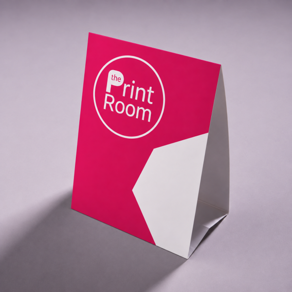 Tent card featuring The Print Room round magenta logo, a modern pink and white geometric design, and a freestanding folded display card on a neutral studio background.