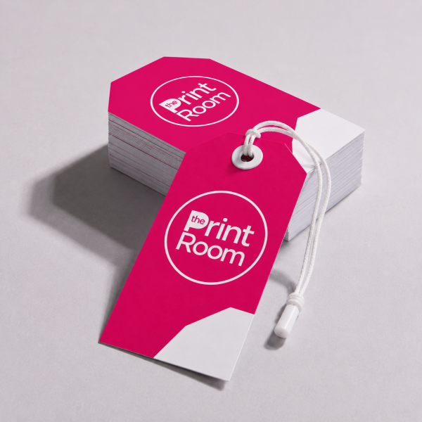 Custom gift tags featuring the Print Room circular logo, supplied with white string ties and displayed alongside a matching stack of tags on a light grey studio background.