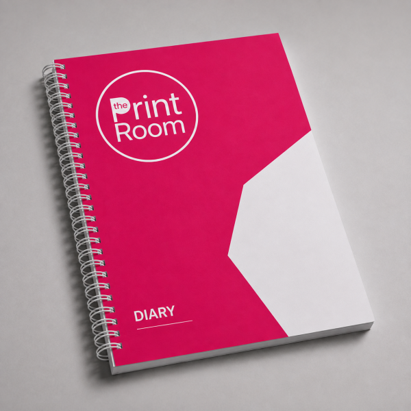 Custom spiral bound diary featuring the Print Room circular logo on a vibrant pink cover with a white geometric design, displayed on a light grey studio background.