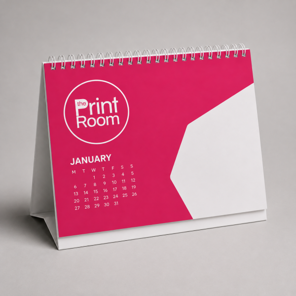 Desktop tent calendar featuring The Print Room round magenta logo, a January monthly calendar, and a modern pink and white geometric design on a spiral-bound stand.